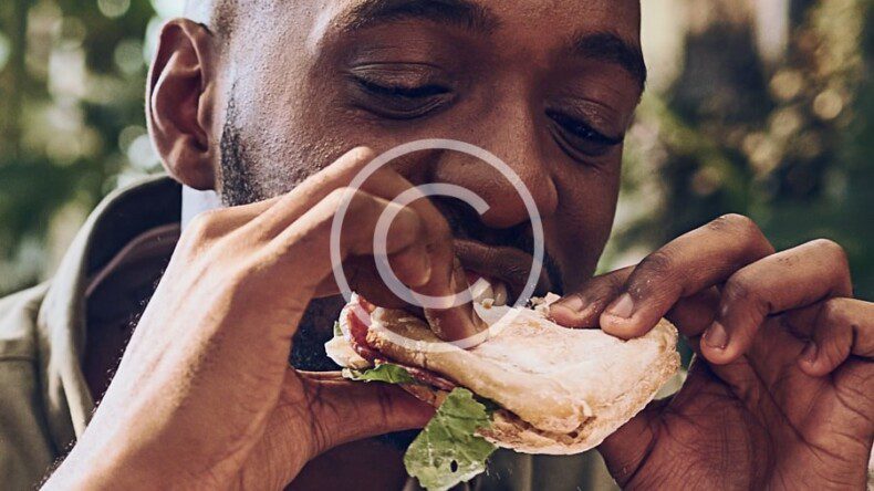 A man eating a sandwich outdoors.