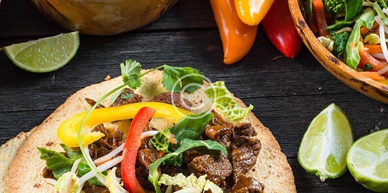 Vietnamese beef tacos on a wooden table.