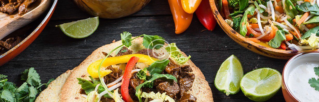Vietnamese beef tacos on a wooden table.