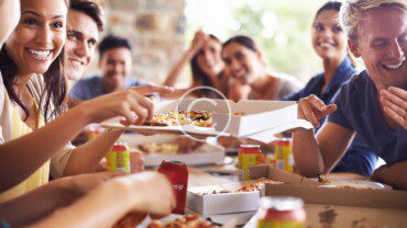 A group of people eating pizza.