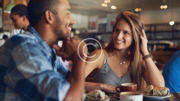 A man and woman sitting at a table in a cafe.
