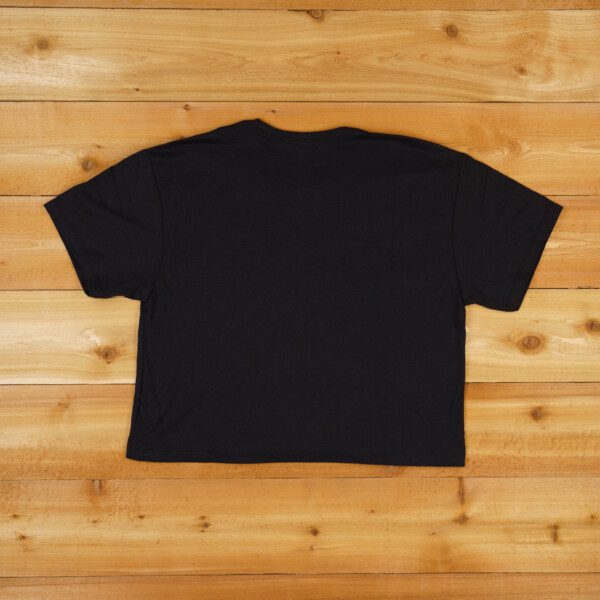 The back of a WRS Crop Tee - Black on a wooden floor.