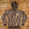 Camo Zip Up Hoodie front A WRS Zip-Up Hoodie - Camo on a wooden floor.