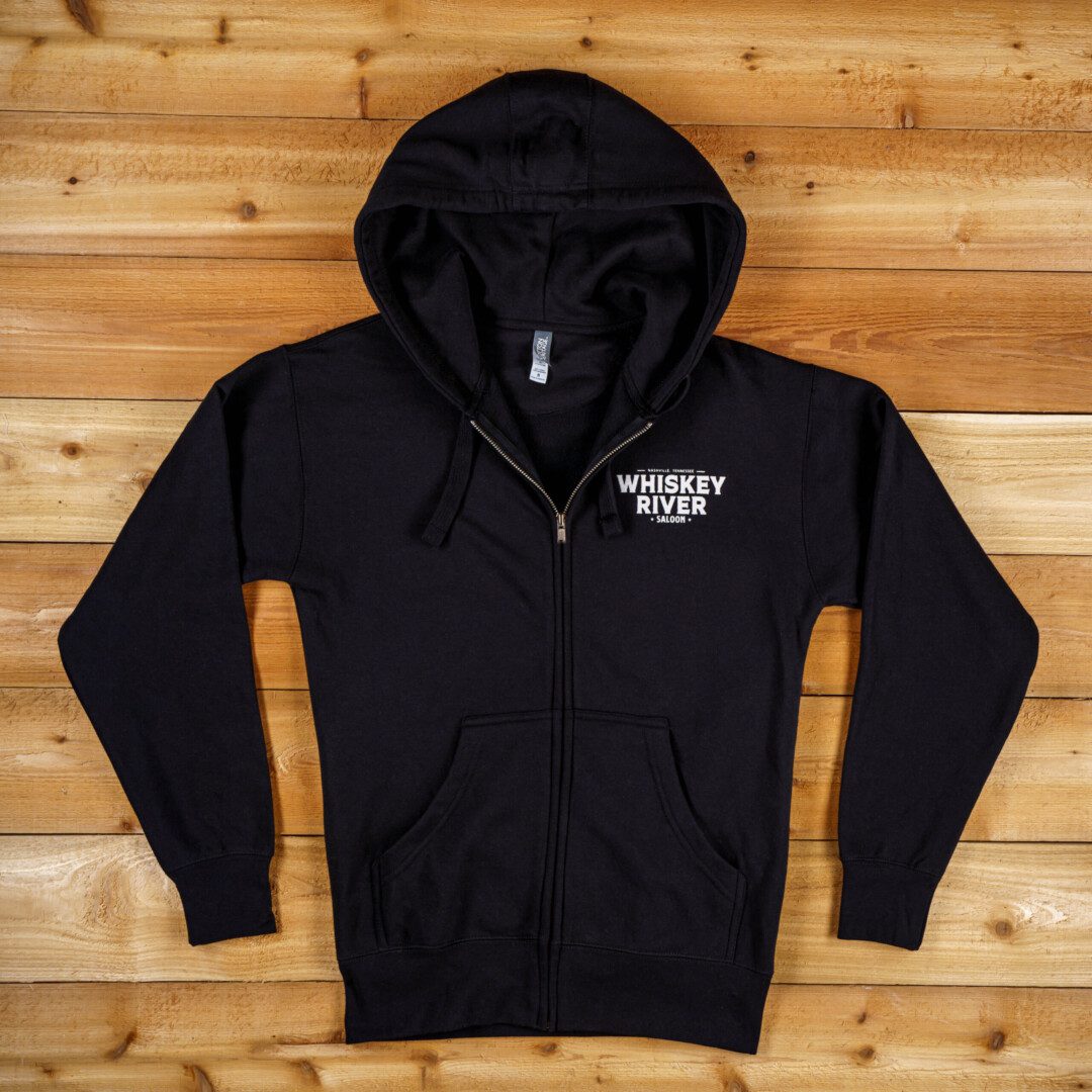 Whiskey river saloon Zip Up Hoodie in Black color and a brown background