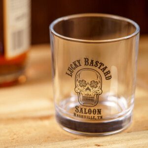 A LBS Rocks Glass with a skull on it sits on a table.