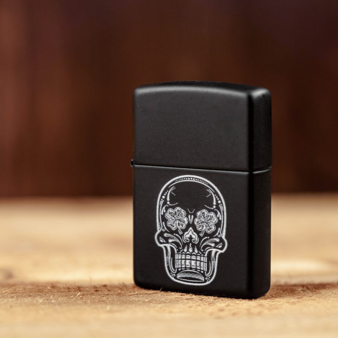 A black LBS Zippo Lighter with a skull on it.
