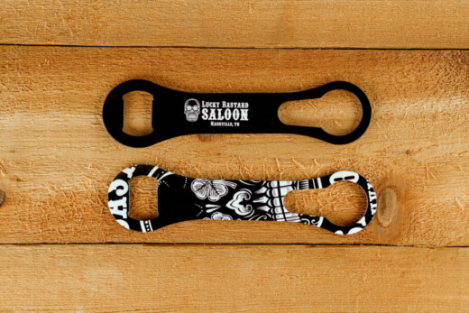 Two skull-themed bottle openers on wood